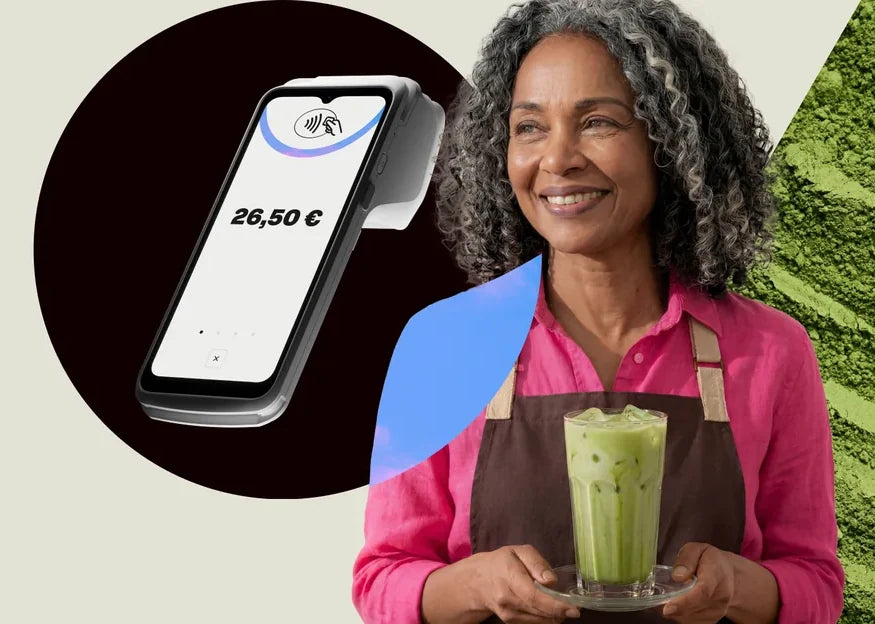 Una commerciante sorridente, con un SumUp Terminal appoggiato accanto a lei